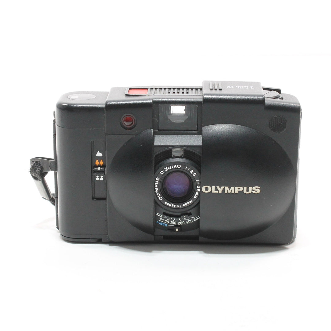 Open front view of black Olympus XA2 revealing D-Zuiko 35mm f/3.5 lens and ISO settings at ClubCamera.com
