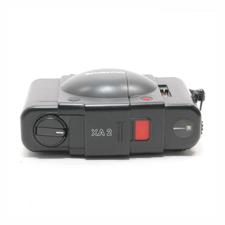 Side profile of compact black Olympus XA2 clamshell film camera with single shot dial at ClubCamera.com
