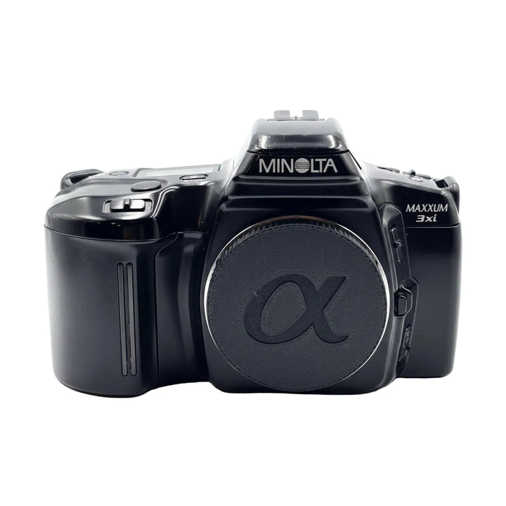 Front view of black Minolta Maxxum 3xi 35mm SLR with retracted flash and alpha logo lens cap from ClubCamera.com
