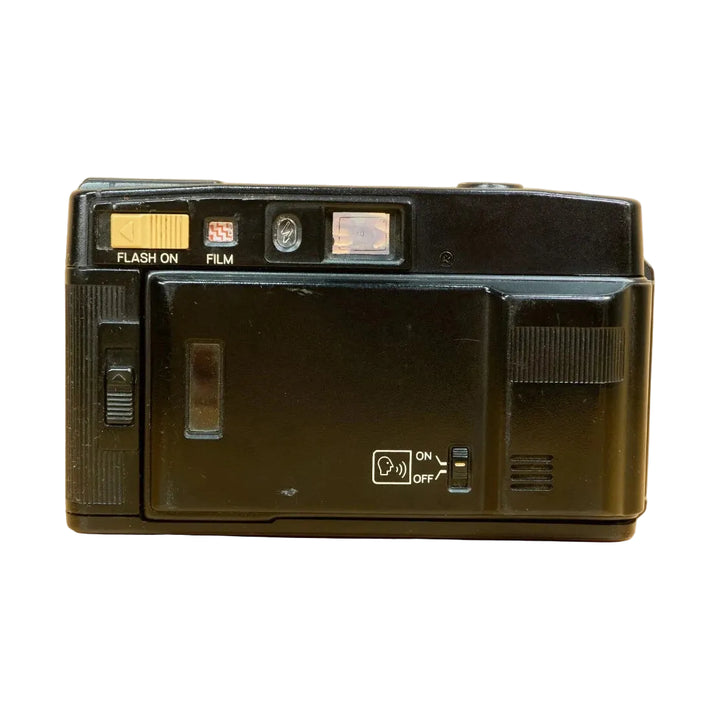 Rear view of black Minolta AF-Sv voice prompt camera with yellow flash slider on wood surface from ClubCamera.com