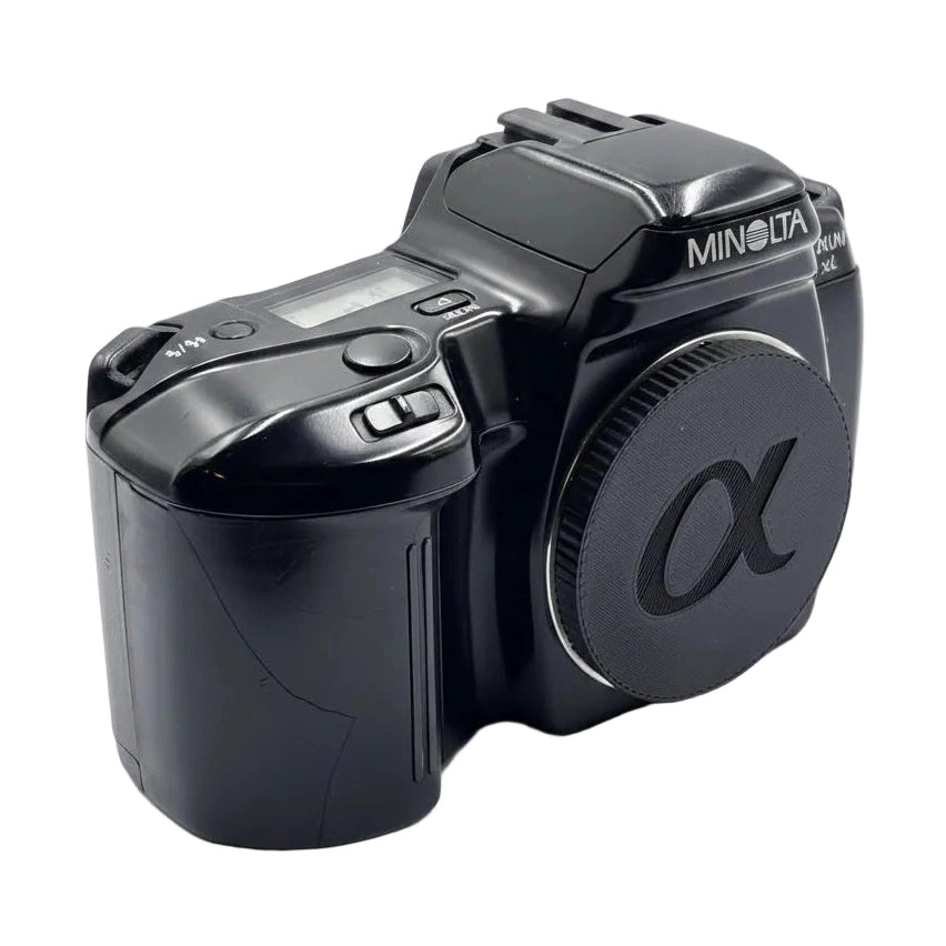 Left side view of Minolta Maxxum 3xi black autofocus SLR showing mode dial and grip texture from ClubCamera.com