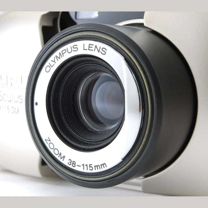 Olympus Stylus Epic Zoom 115 front lens close-up showing 38-115mm zoom ring details at ClubCamera.com