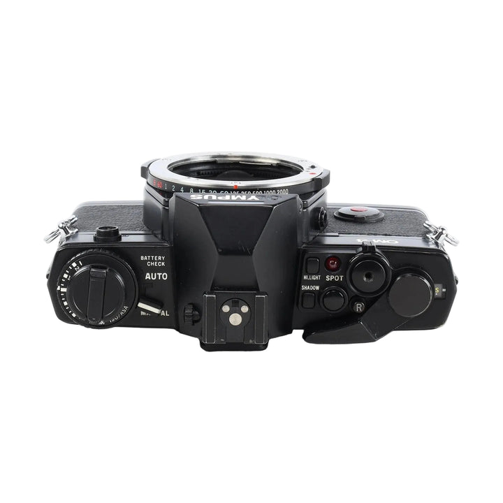 Angled top view of black Olympus OM-4 35mm film camera with aperture scale markings and red LED indicator at ClubCamera.com
