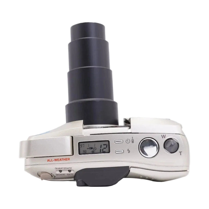 ClubCamera silver Olympus Stylus Epic Zoom 140 top view showing extended zoom lens, LCD screen, and all-weather label